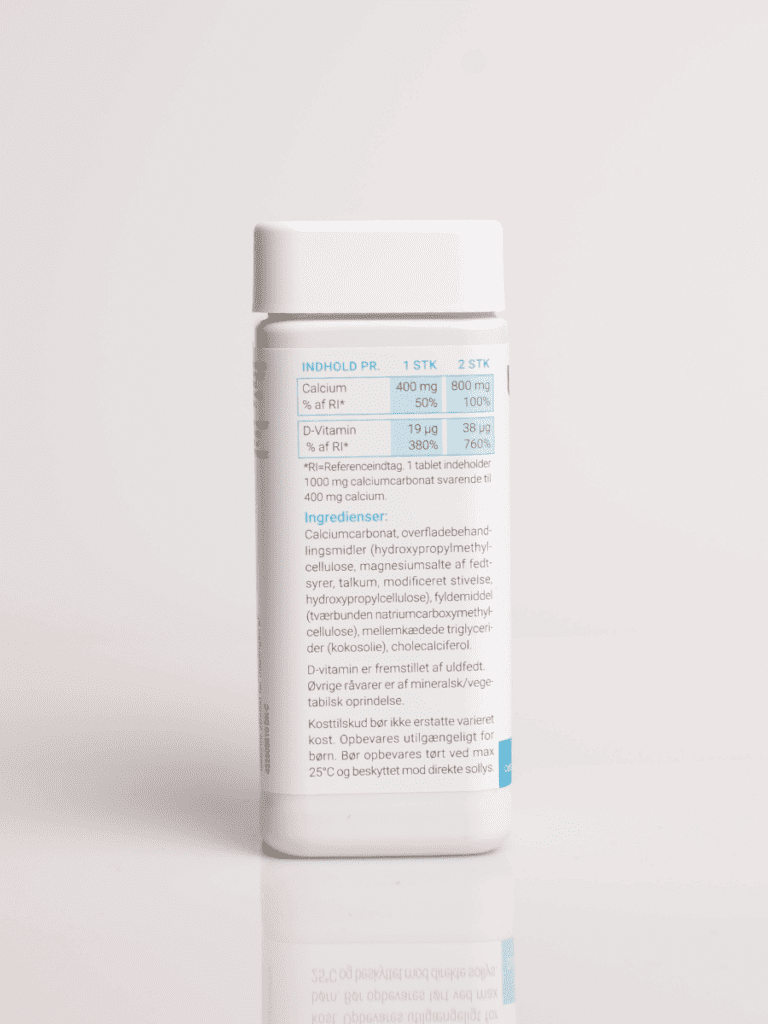 Weißer Behälter mit Nahrungsergänzungsmittel und Etikett mit Nährwertangaben zu Calcium und Vitamin D